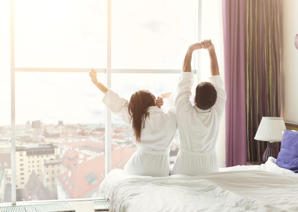 Young couple waking up in the morning in hotel room