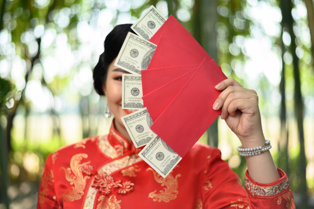 Asian pretty chinese woman in cheongsam holding envelopen with b