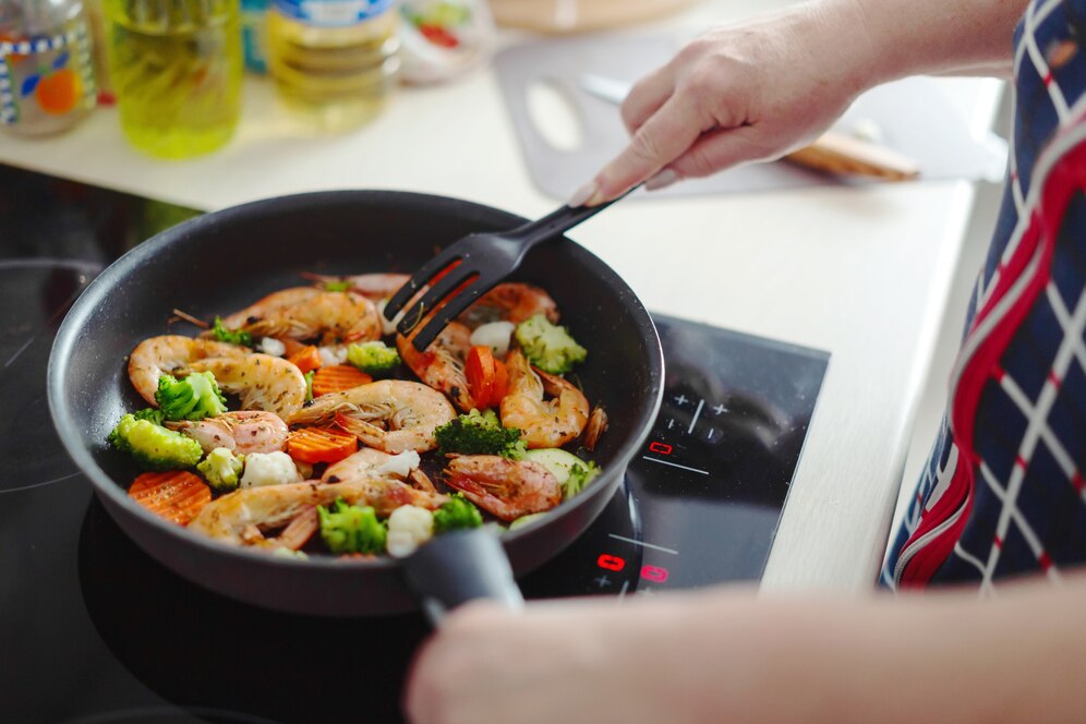 Woman staying home kitchen cooking shrimps with vegetables pan home cooking healthy cooking concept 1220 6308