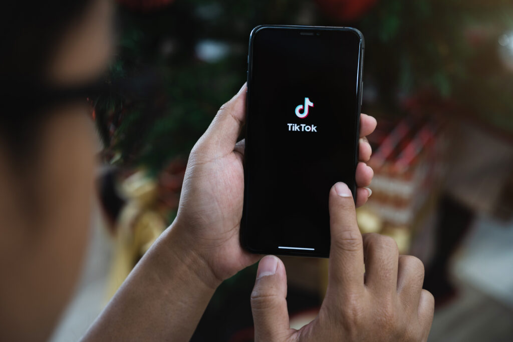Closed up image of a male using tiktok application on a smartpho