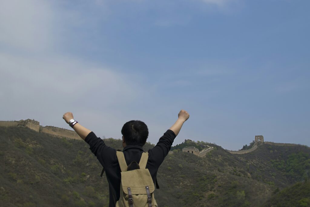 Rear view man with arm raised standing great wall china