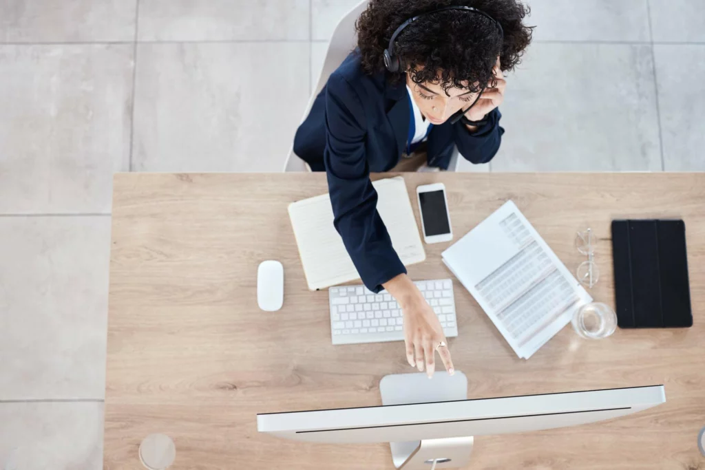 上班族在辦公桌前配戴耳機，利用零碎時間專注處理電腦工作