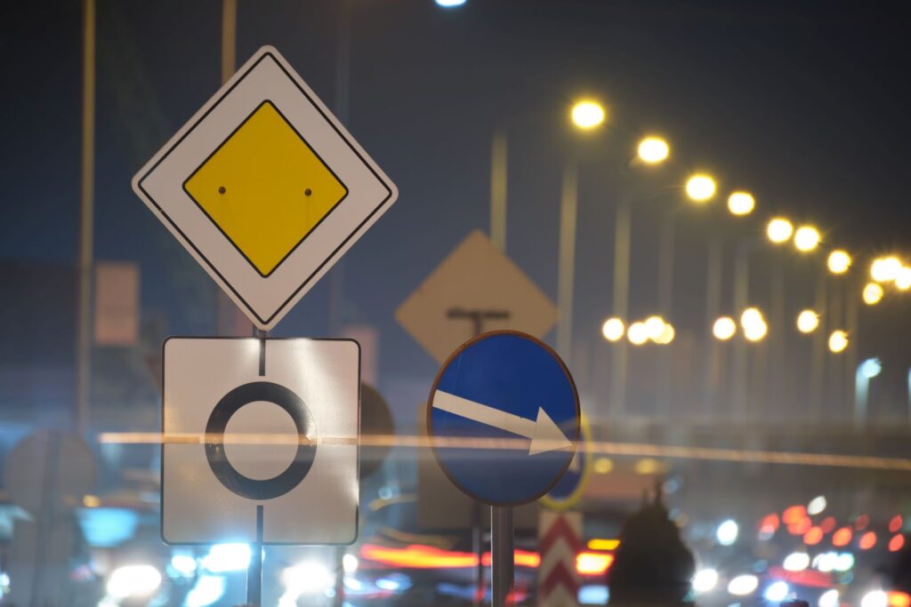 Roundabout road signs with blurred cars city street traffic night urban transportation concept